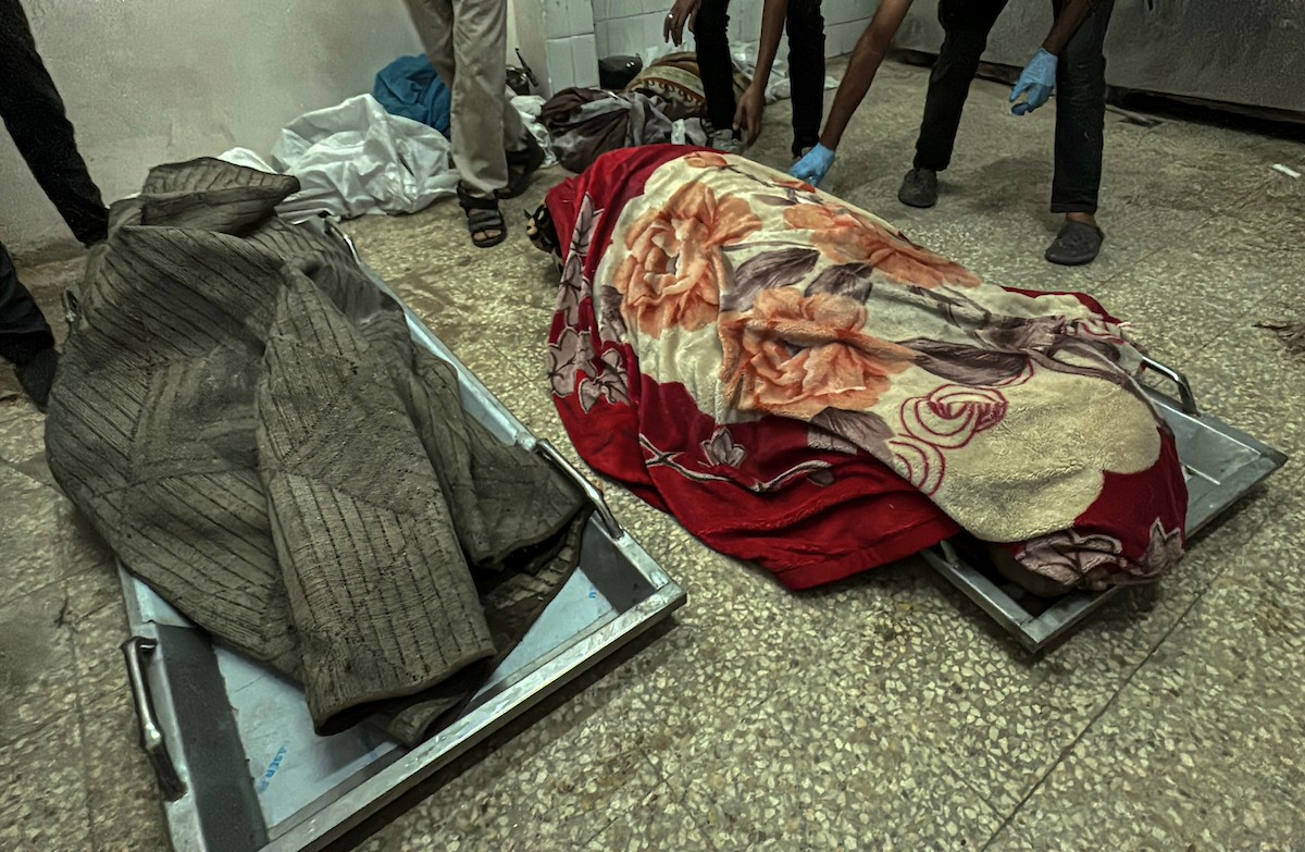 فلسطينيون ينقلون الشهداء والجرحى إلى مستشفى شهداء الأقصى بعد أن استهدفت الغارات الإسرائيلية منازل متفرقة في دير البلح وسط قطاع غزة في 22 نوفمبر 2025.jpg