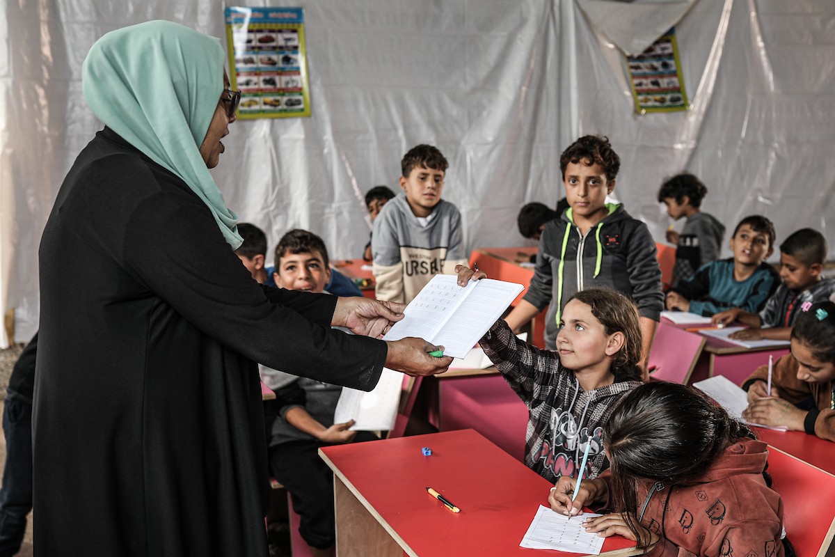 أطفال فلسطينيون نازحون يحضرون درسًا داخل خيمة تُستخدم كفصل دراسي مؤقت في ملجأ بدير البلح (12).jpg