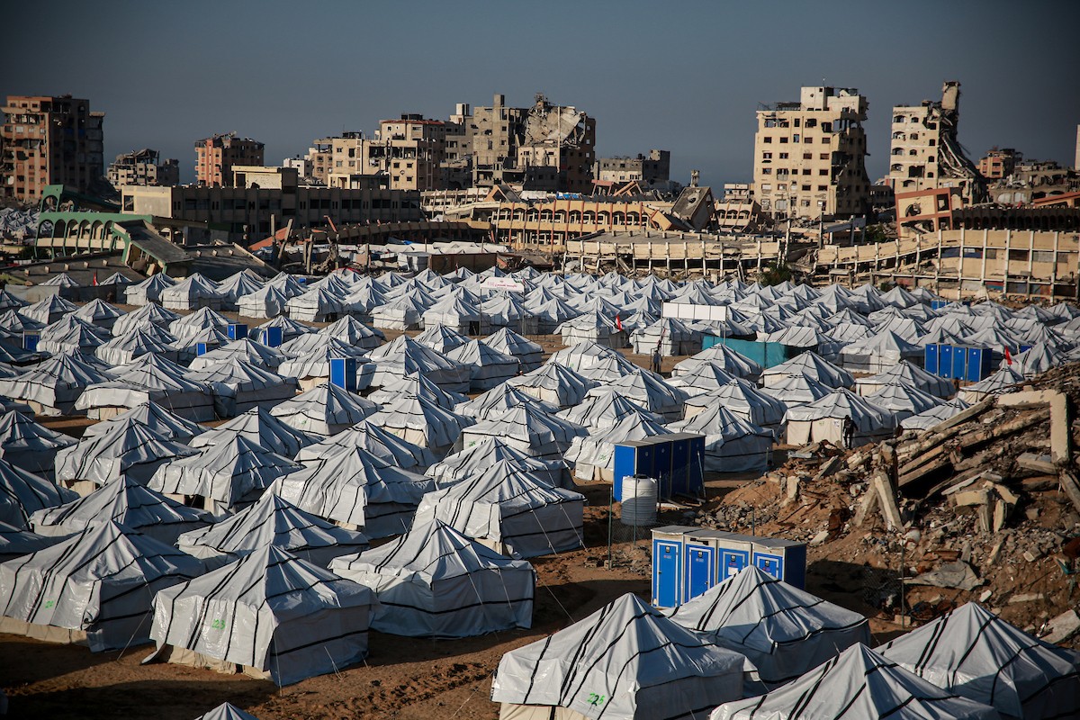 نازحون فلسطينيون يسيرون وسط ملاجئ مؤقتة شمال مدينة غزة