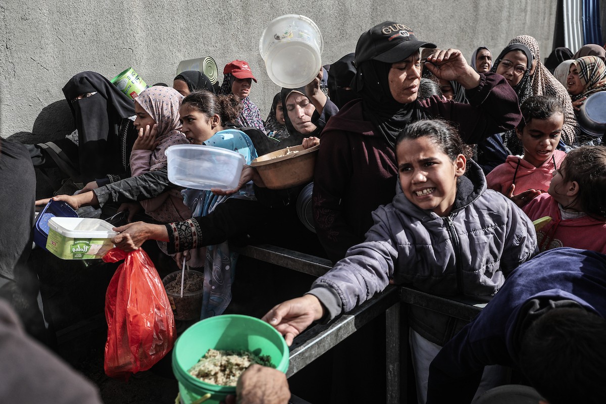 فلسطينيون في مخيم النصيرات وسط قطاع غزة يتلقون وجبات ساخنة من جمعية خيرية للنازحين