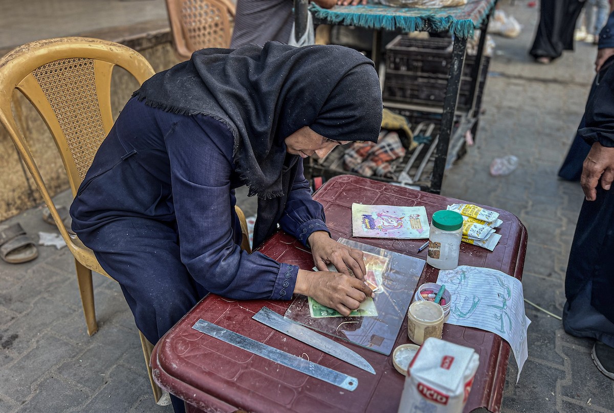 الفلسطينية منال السعيداني تُصلح أوراقًا نقدية قديمة ومهترئة في ظل نفاد العملة الصعبة في قطاع غزة.jpg