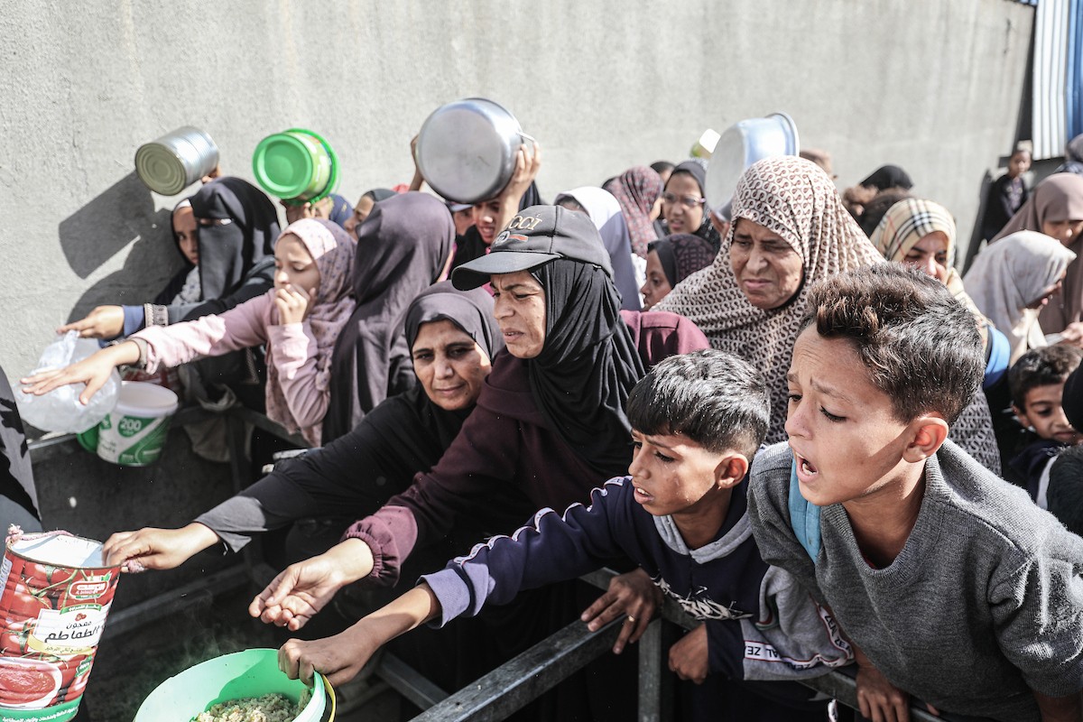 فلسطينيون في مخيم النصيرات وسط قطاع غزة يتلقون وجبات ساخنة من جمعية خيرية للنازحين