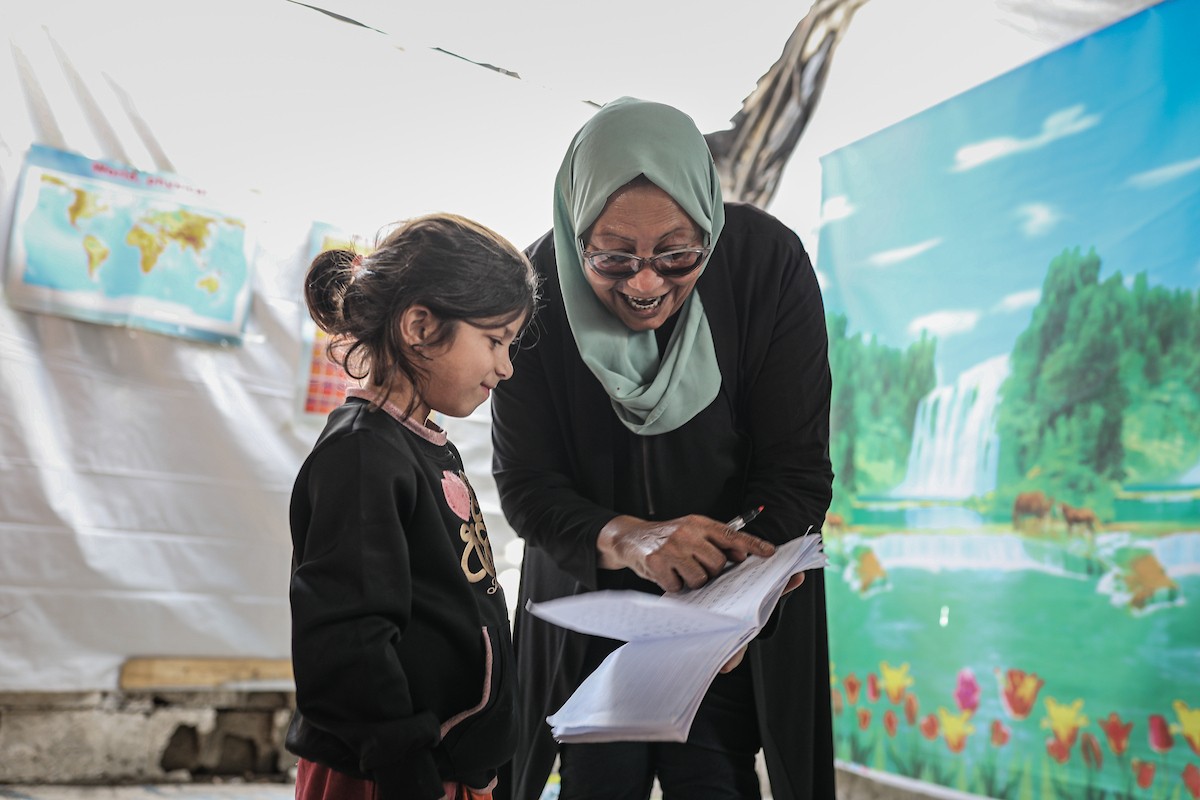 أطفال فلسطينيون نازحون يحضرون درسًا داخل خيمة تُستخدم كفصل دراسي مؤقت في ملجأ بدير البلح (8).jpg
