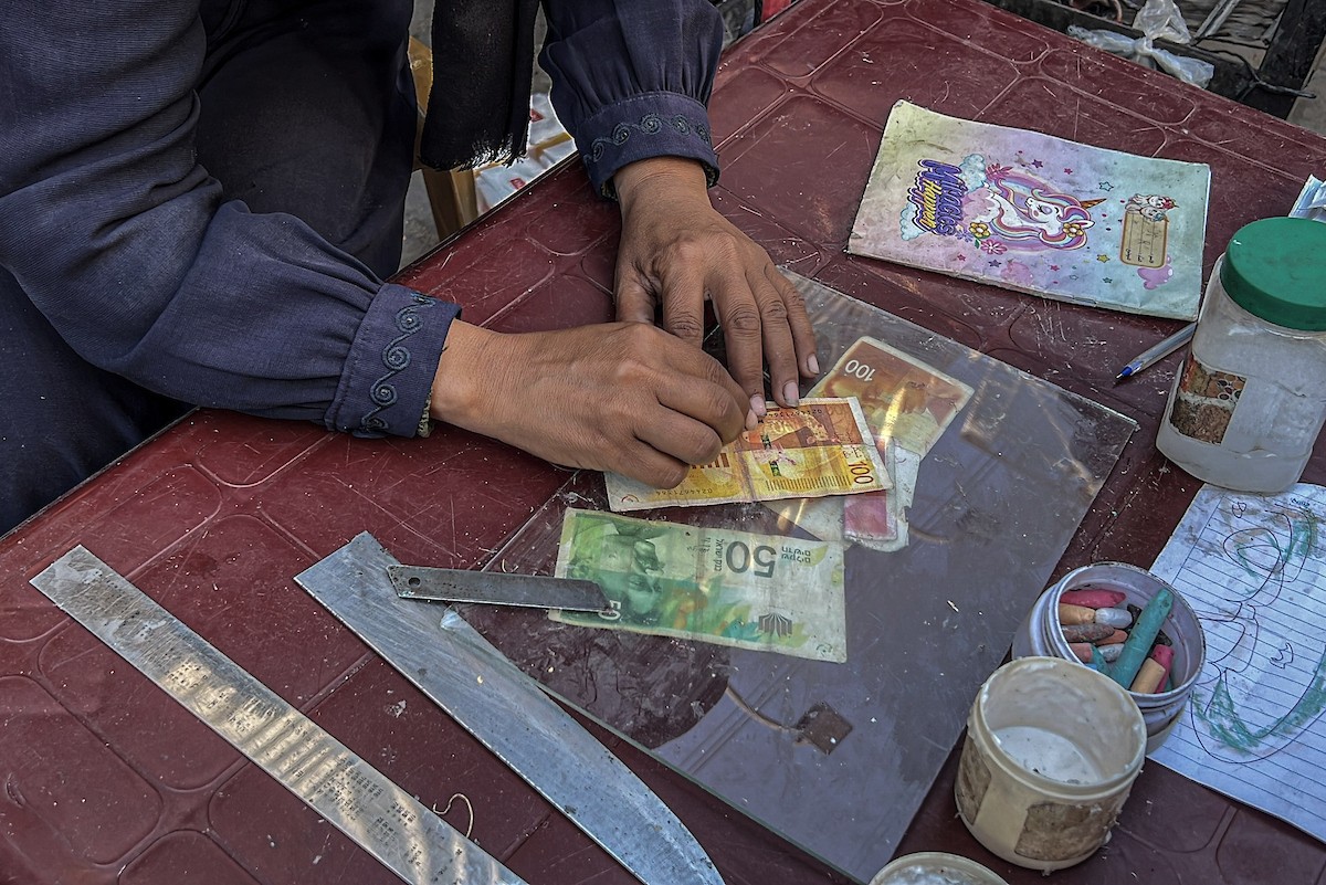 الفلسطينية منال السعيداني تُصلح أوراقًا نقدية قديمة ومهترئة في ظل نفاد العملة الصعبة في قطاع غزة (6).jpg