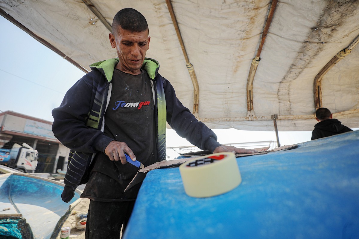 حرفيون يُصلحون قوارب الصيد في ورشة بميناء غزة البحري (3).jpg