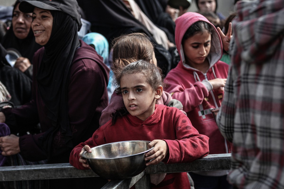 فلسطينيون في مخيم النصيرات وسط قطاع غزة يتلقون وجبات ساخنة من جمعية خيرية للنازحين