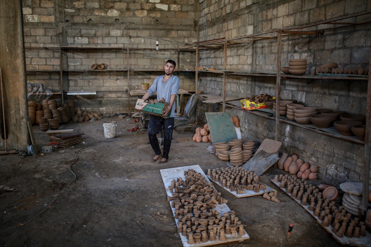 يعمل حرفيو الفخار الفلسطينيون في ورشتهم الصغيرة، حيث يُنتجون أدوات منزلية وأدوات مائدة باستخدام.jpg