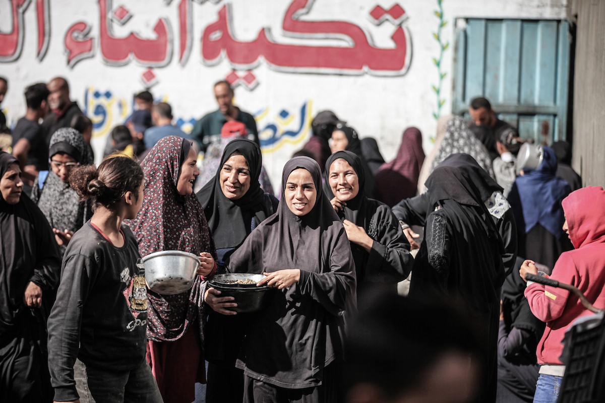 فلسطينيون في مخيم النصيرات وسط قطاع غزة يتلقون وجبات ساخنة من جمعية خيرية للنازحين