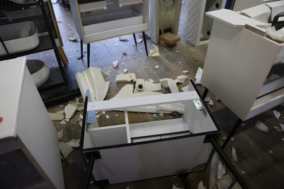 يتفقد الفلسطيني محمد مرقة متجره المتضرر بعد أن هاجمته مجموعة من المستوط (9).JPG