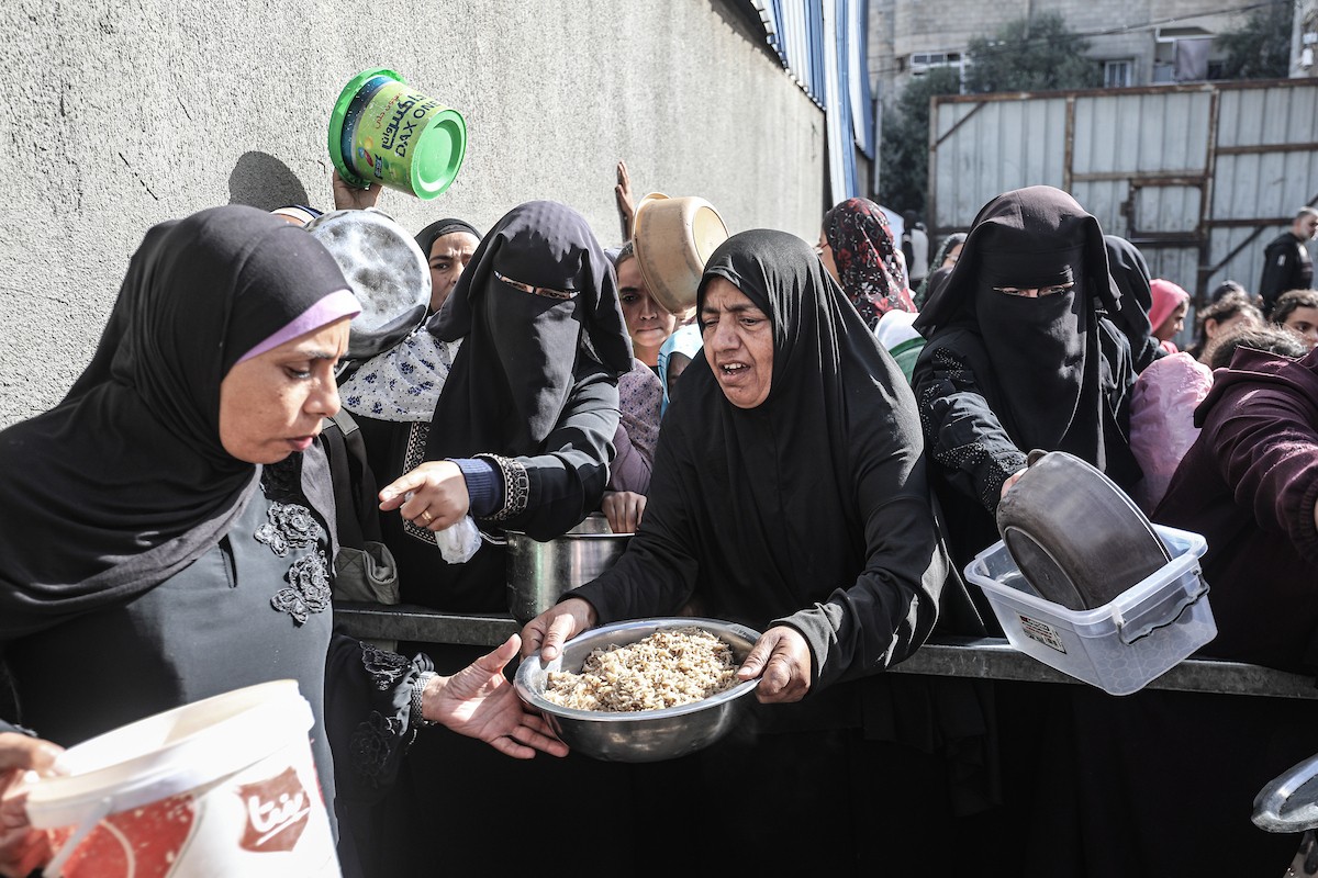 فلسطينيون في مخيم النصيرات وسط قطاع غزة يتلقون وجبات ساخنة من جمعية خيرية للنازحين