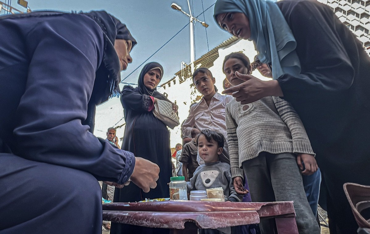 الفلسطينية منال السعيداني تُصلح أوراقًا نقدية قديمة ومهترئة في ظل نفاد العملة الصعبة في قطاع غزة (17).jpg