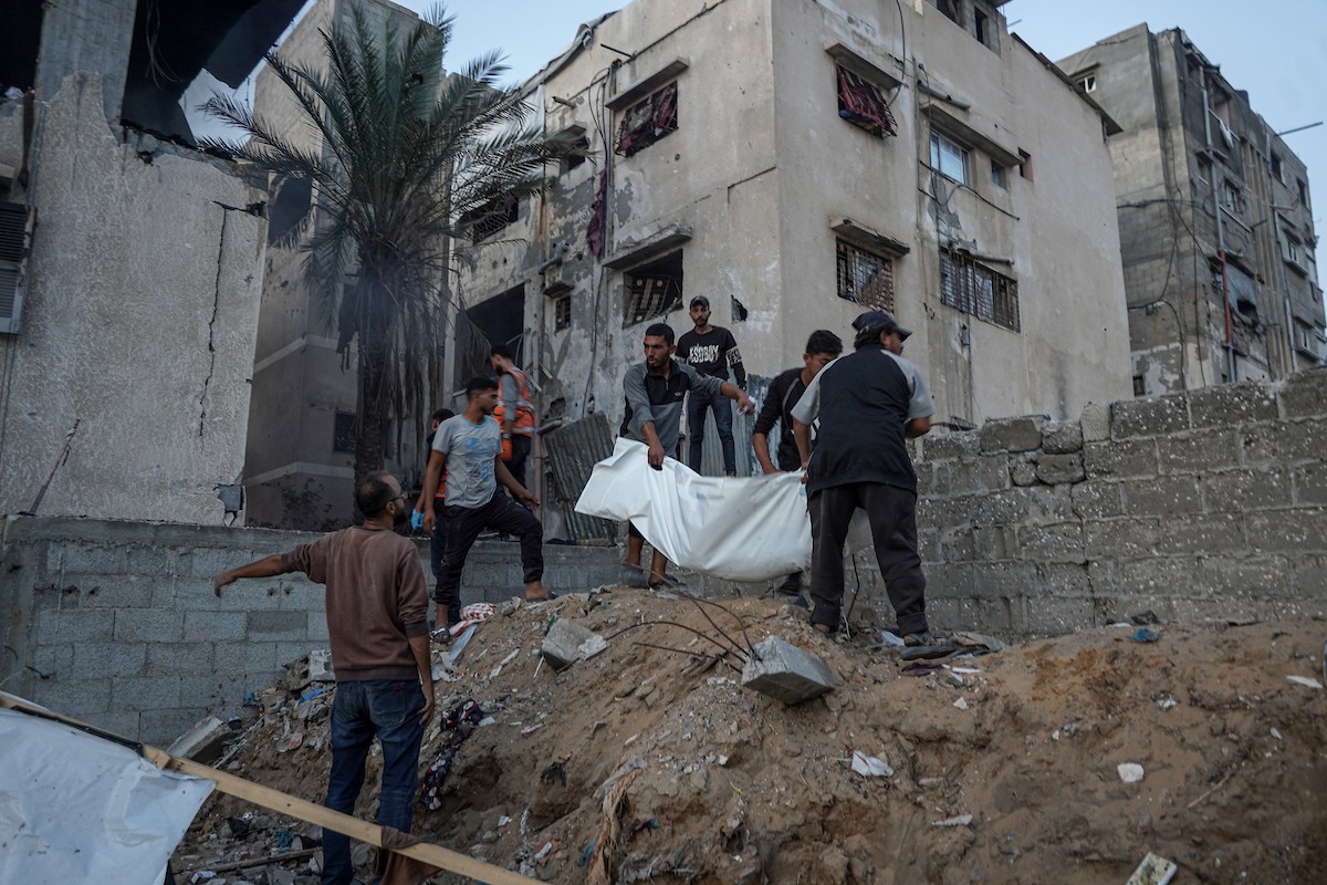 أفراد الدفاع المدني يبحثون في منزل محترق استهدفه غارات جوية إسرائيلية في مدينة غزة، في 22 نوفمبرتشرين الثاني 2025.jpg