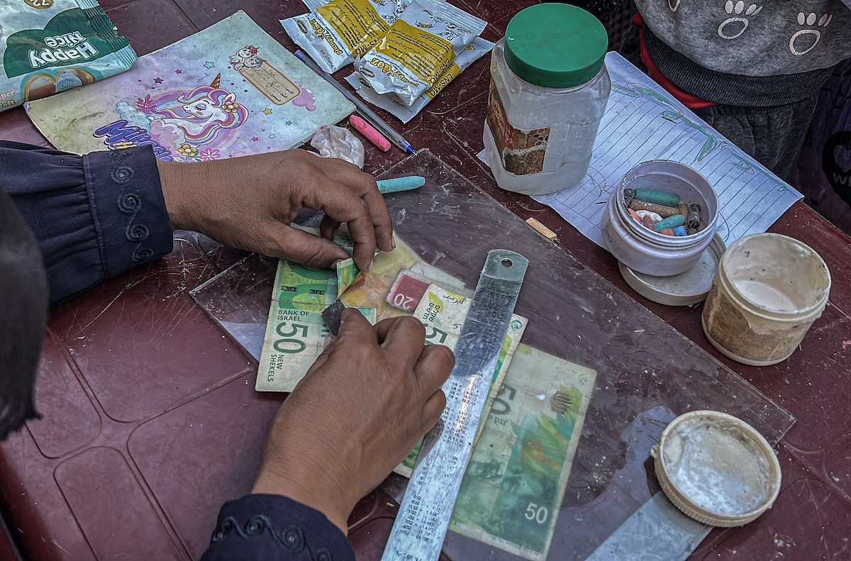 الفلسطينية منال السعيداني تُصلح أوراقًا نقدية قديمة ومهترئة في ظل نفاد العملة الصعبة في قطاع غزة (19).jpg