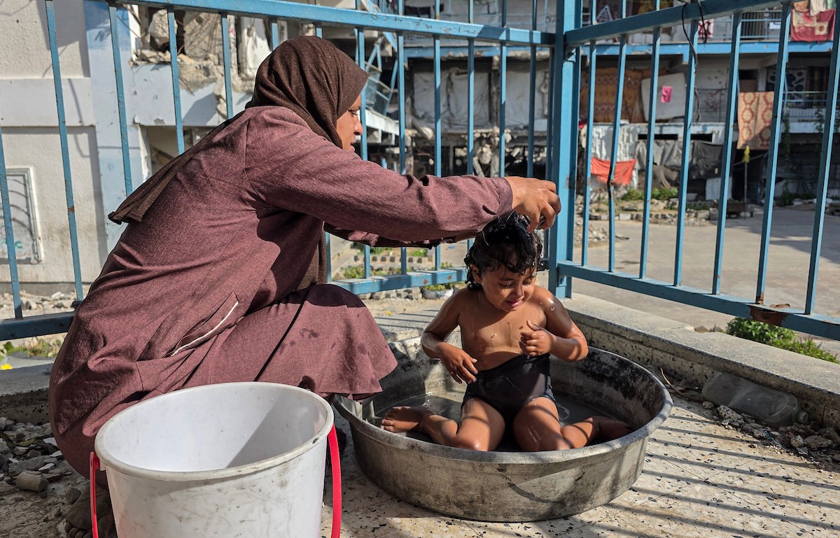 امرأة فلسطينية تأوي مع أطفالها داخل مدرسة مدمرة قرب خط التماس الخط الأصفر شرق خان يونس (8).jpg
