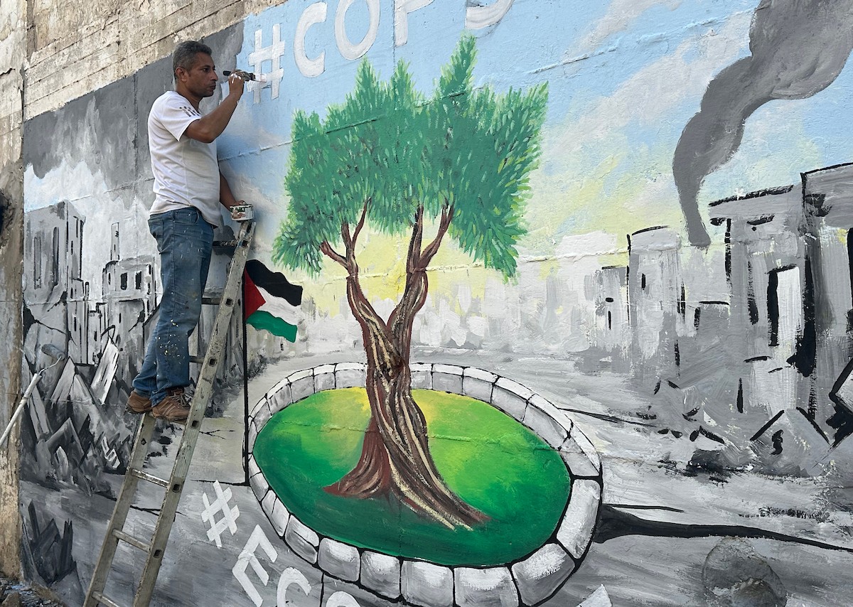 يرسم فنانون فلسطينيون جدارية وسط أنقاض المباني المدمرة في خان يونس، جنوب قطاع غزة (7).jpg