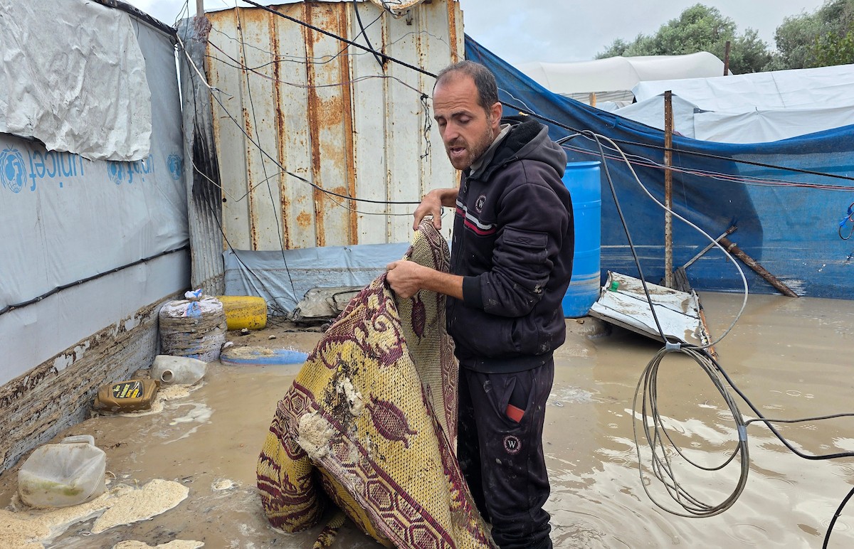 يُكافح الفلسطينيون النازحون، المقيمون في خيام مؤقتة، من أجل البقاء في ظل ظروف قاسية، حيث تجتاح الأمطار والعواصف الشديدة منطقة المواصي، غرب خان يونس، جنوب قطاع غزة، في 28 ديسمبر/كانون الأول 2025. (صورة: طارق محمد)