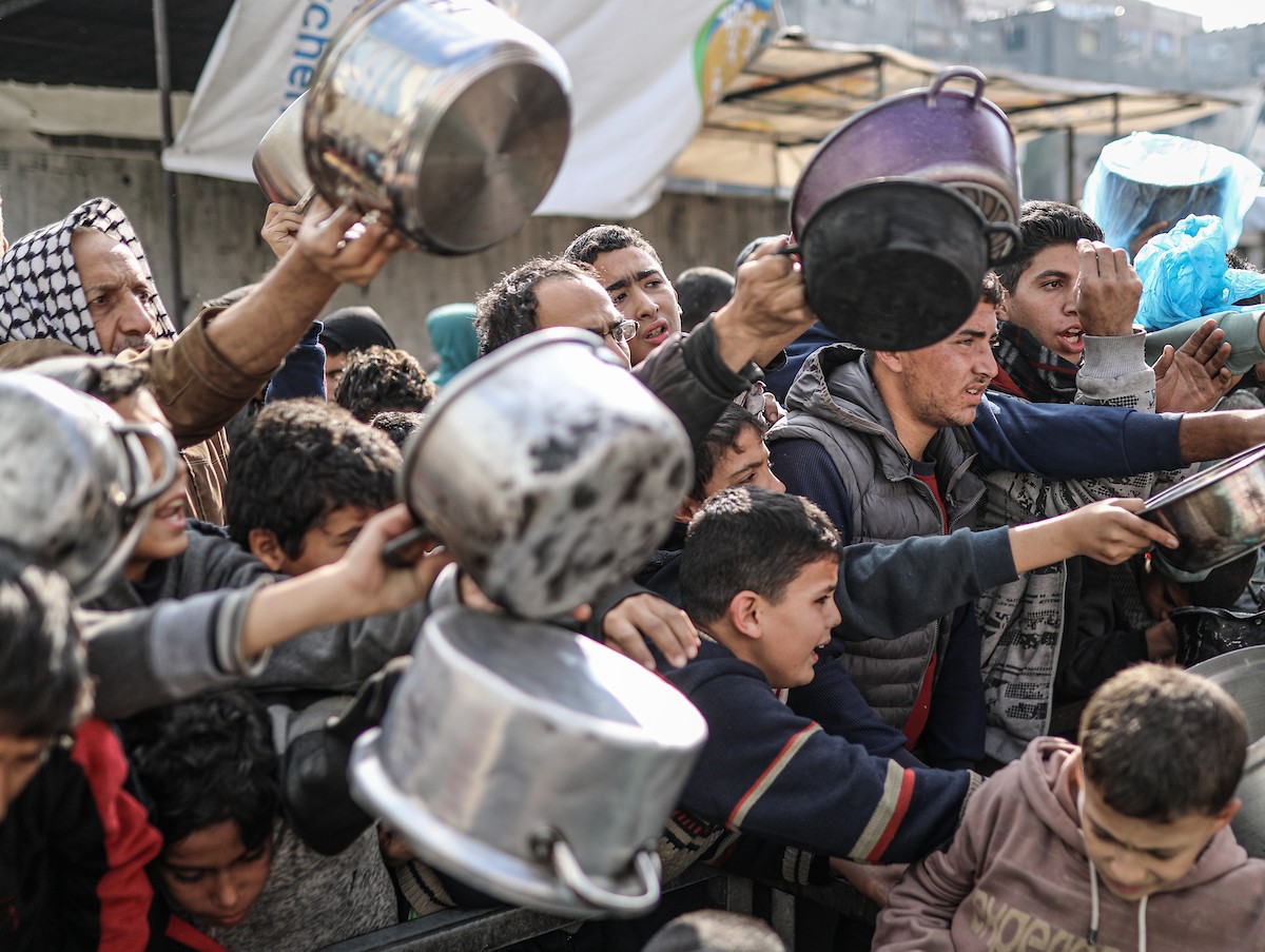 يصطفّ فلسطينيون لتلقّي الطعام من مطبخ خيري في تجمع للنازحين بمخيم النصيرات للاجئين، وسط قطاع غزة. ١٧ ديسمبر/كانون الأول ٢٠٢٥. تصوير: رمزي أبو عامر / (apa)