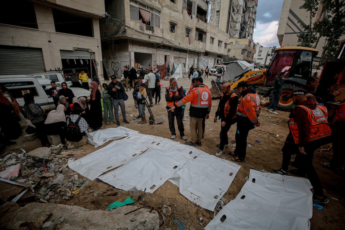 عمال الدفاع المدني الفلسطيني يبحثون عن جثث في مبنى منهار يعود لعائلة سالم، استُهدف بغارات إسرائيلية في بداية الحرب، في شارع الجلاء بمدينة غزة، يوم الاثنين 15 ديسمبر/كانون الأول 2025. صورة: عمر أشتوي