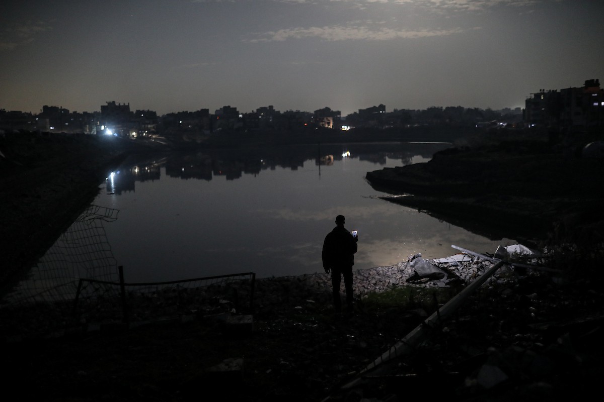 يعيش الفلسطينيون حياتهم اليومية ليلاً في خيام نصبت فوق أنقاض المباني المدمرة في حي الشيخ رضوان وسط مدينة غزة، 5 ديسمبر/كانون الأول 2025.تصوير: عمر أشتوي
