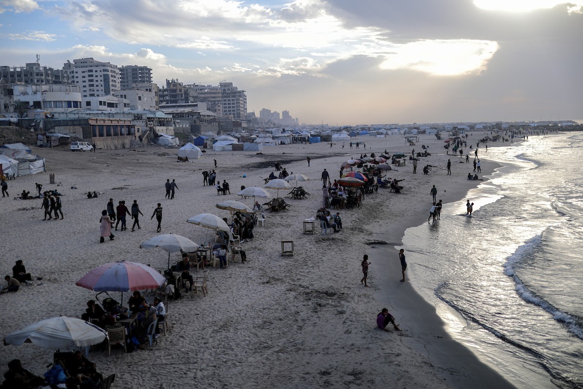 يقضي فلسطينيون نازحون وقتًا على الشاطئ مقابل خيامهم الممتدة على طول ميناء غزة، في غزة، 5 ديسمبر/كانون الأول 2025. تصوير: عمر أشتوي