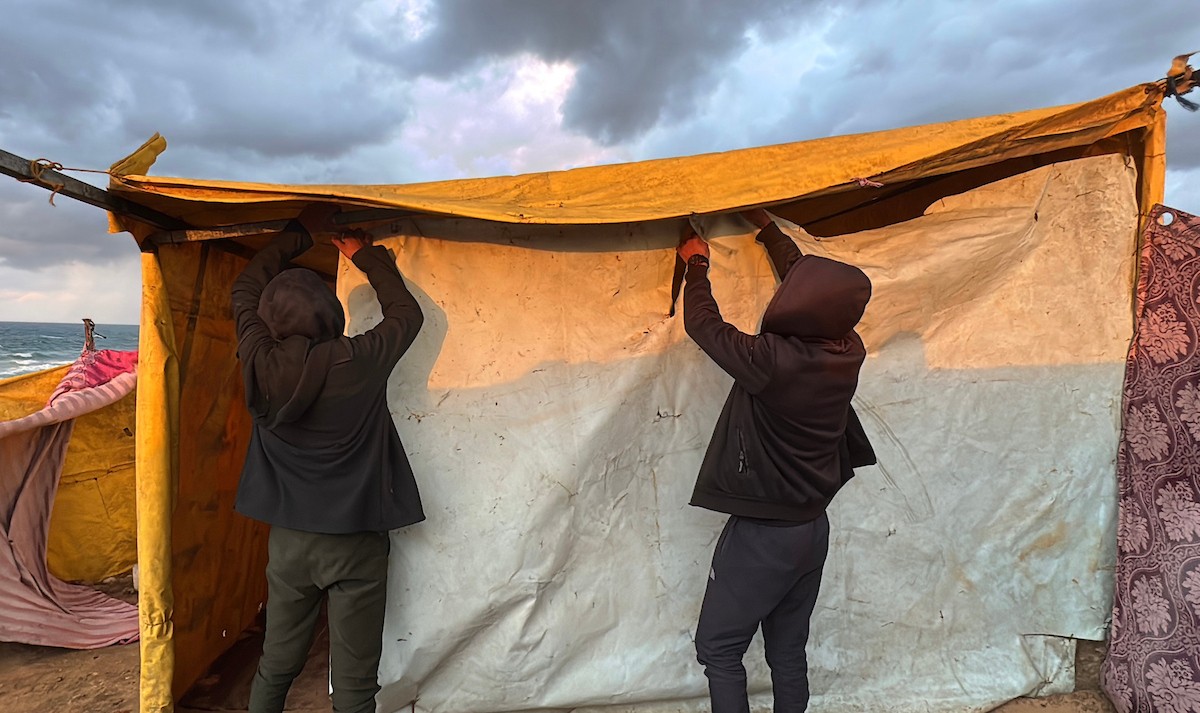 يُكافح الفلسطينيون النازحون، المقيمون في خيام مؤقتة، من أجل البقاء في ظل ظروف قاسية، حيث تجتاح الأمطار والعواصف الشديدة دير البلح، وسط قطاع غزة، في 28 ديسمبركانون الأول 2025. صورة أحمد إبراهيم(APA)