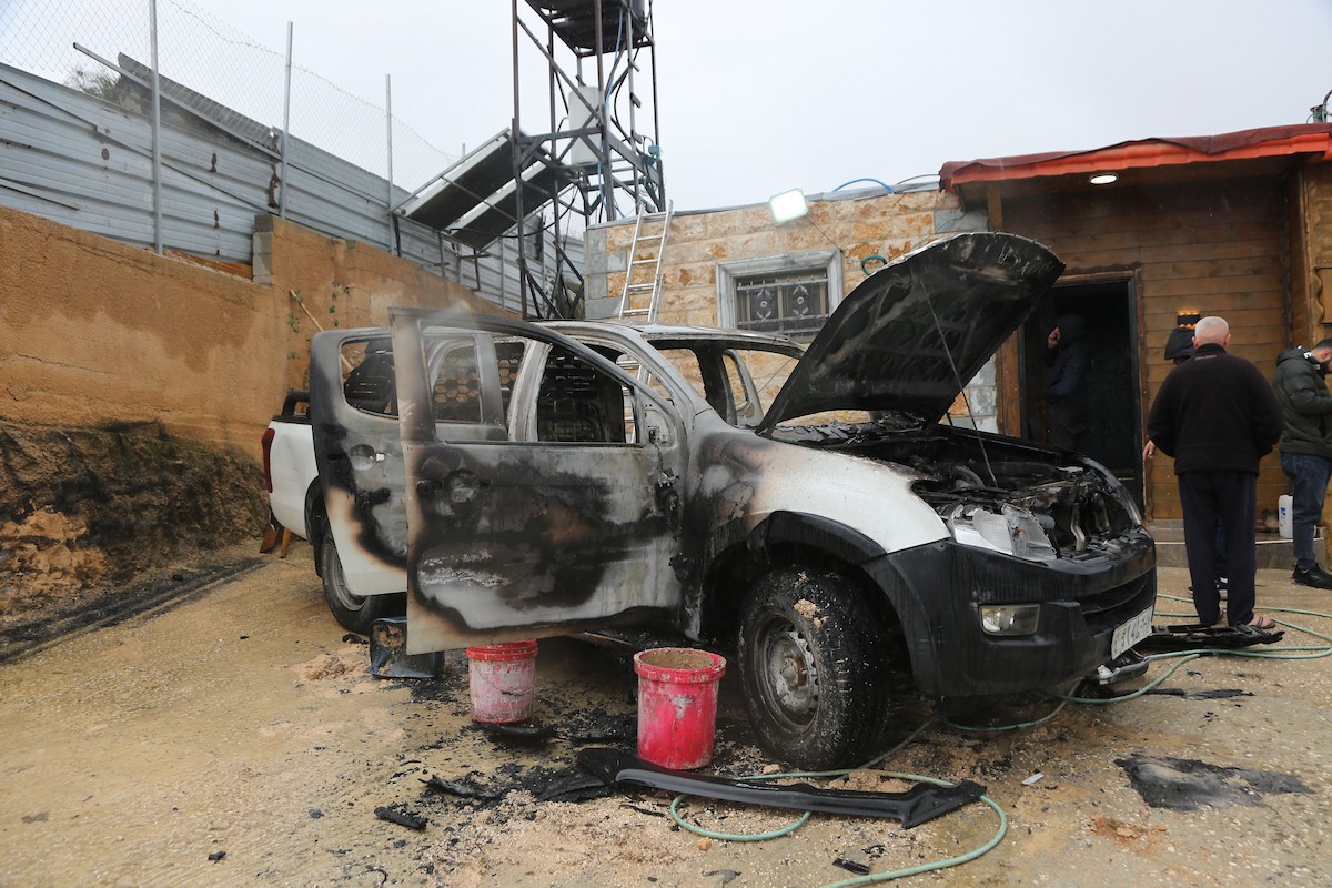 فلسطينيون يقفون في موقع حريق سيارة أشعله مستوطنون إسرائيليون في بلدة حوارة، جنوب نابلس في الضفة الغربية، 28 ديسمبر/كانون الأول 2025. صورة: محمد ناصر