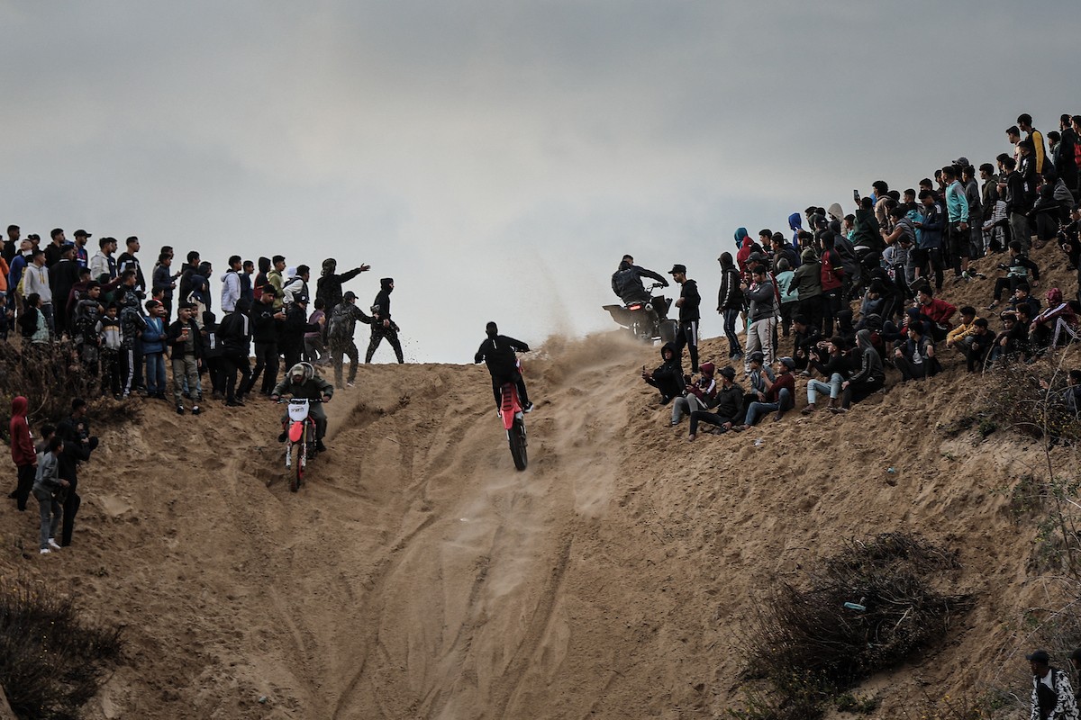 شبان فلسطينيون يركبون الدراجات النارية على الكثبان الرملية في بلدة الزهراء، بعد انقطاع دام عامين عن هذه الرياضة بسبب الحرب واحتلال الجيش الإسرائيلي للمنطقة المعروفة سابقا بمحور