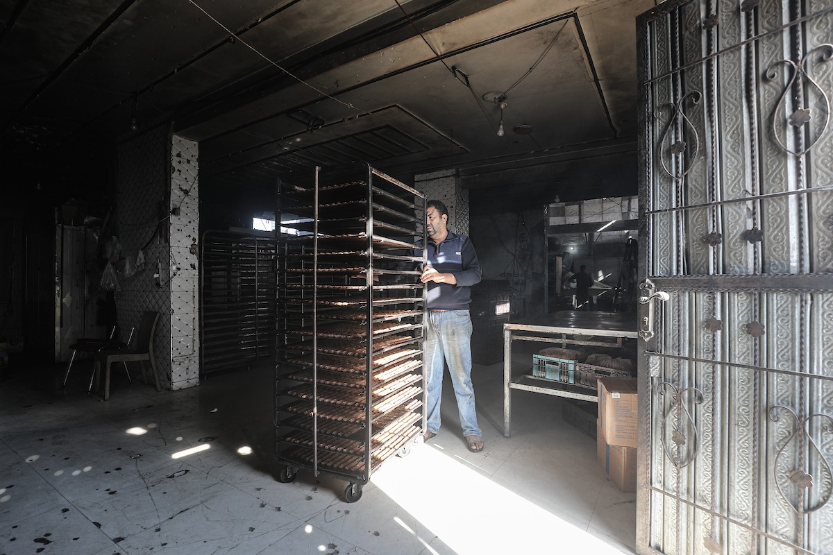 عمال فلسطينيون يعيدون تشغيل أحد أقدم المخابز في مخيم النصيرات للاجئين بعد إغلاقه لمدة عامين بسبب الحرب (30).jpg