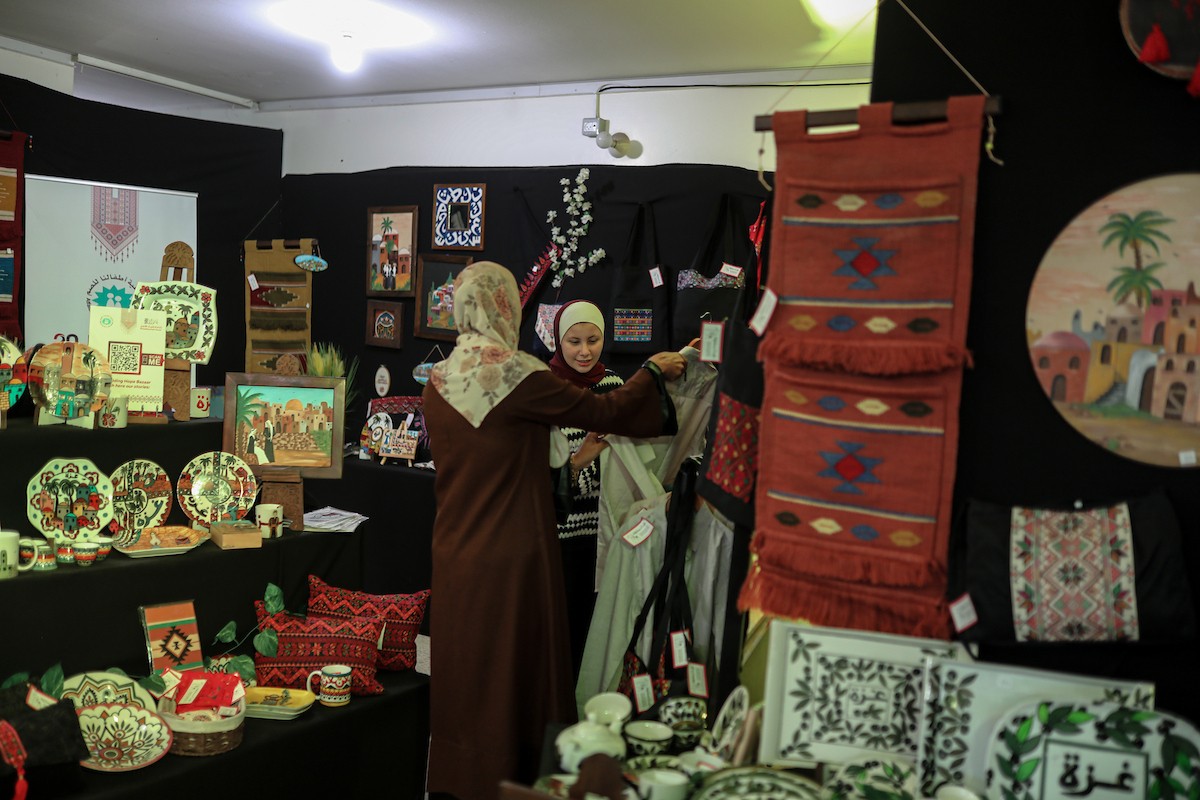 فلسطينيون يحضرون معرضًا يعرض منتجات يدوية من صنع مجموعة من الحرفيين الصم في مدينة غزة