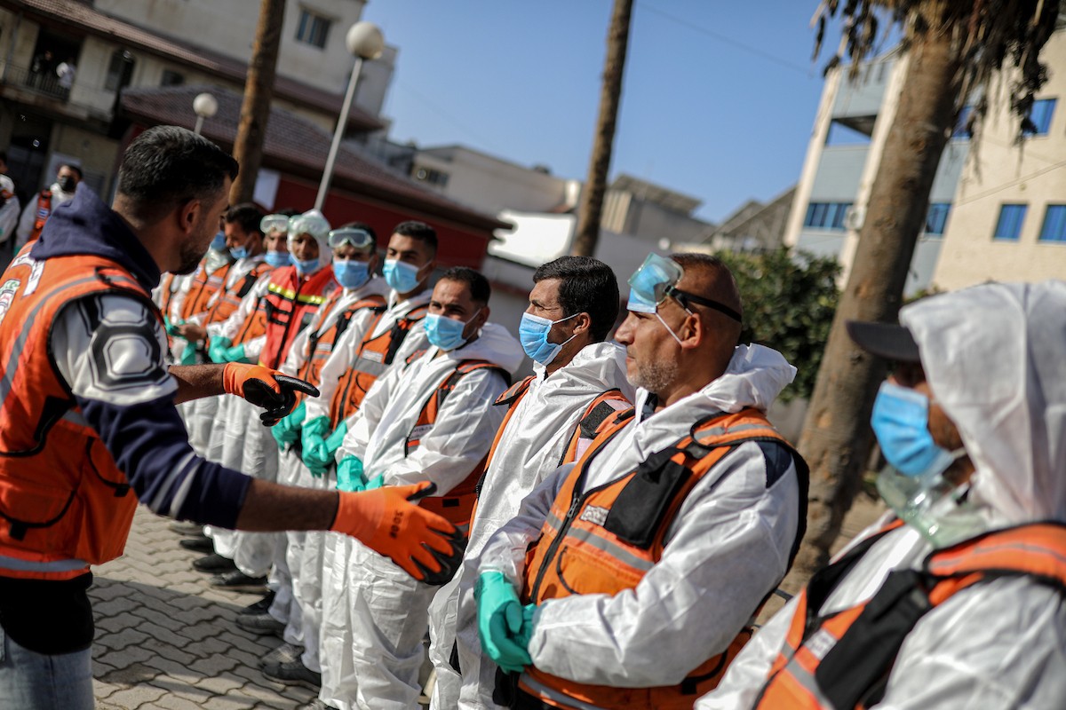 منقذون ومتطوعون فلسطينيون يستخرجون جثث ضحايا الحرب من مقبرة مؤقتة داخل المستشفى العربي المعمداني بمدينة غزة، ليعاد دفنها