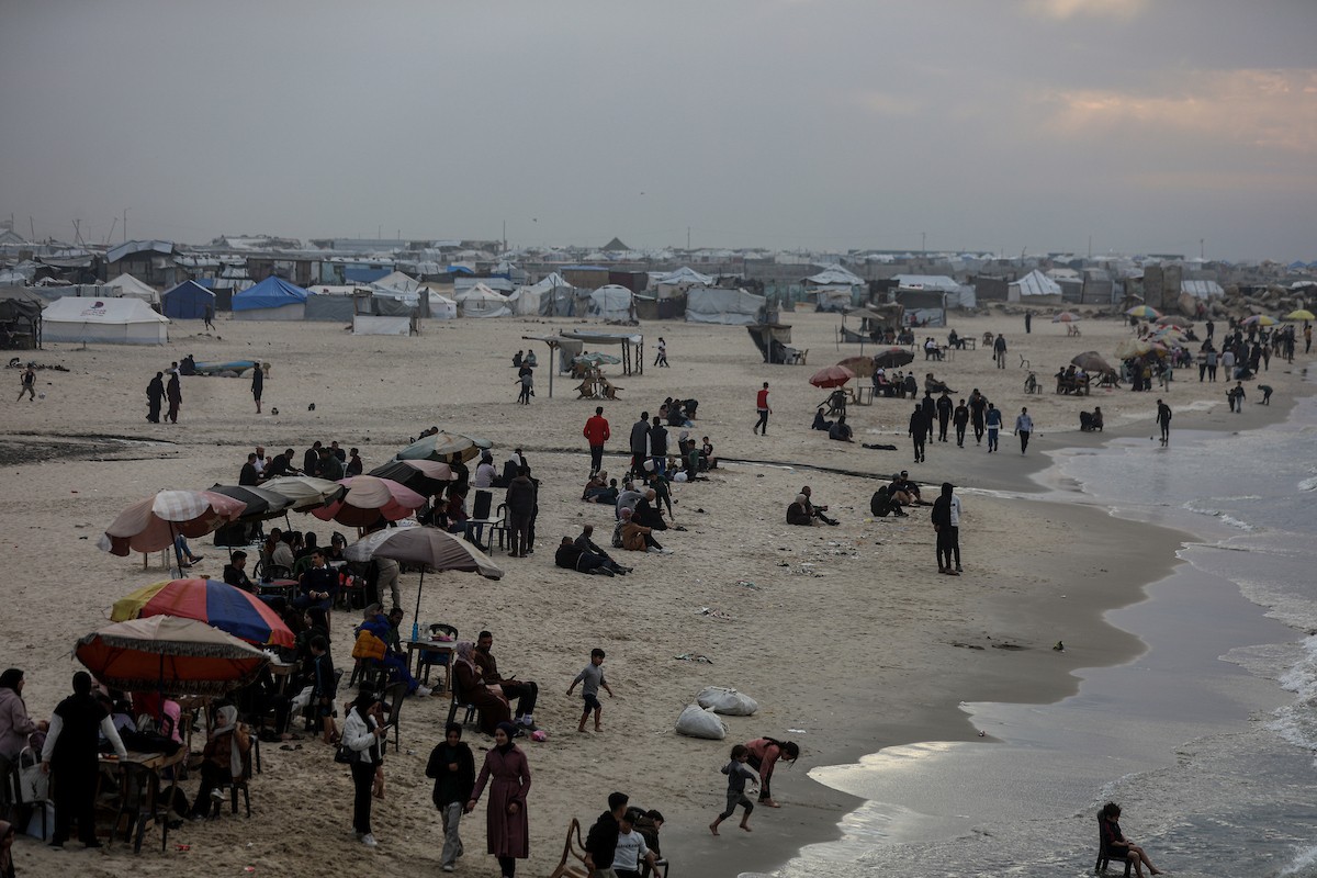 يقضي فلسطينيون نازحون وقتًا على الشاطئ مقابل خيامهم الممتدة على طول ميناء غزة، في غزة، 5 ديسمبر/كانون الأول 2025. تصوير: عمر أشتوي