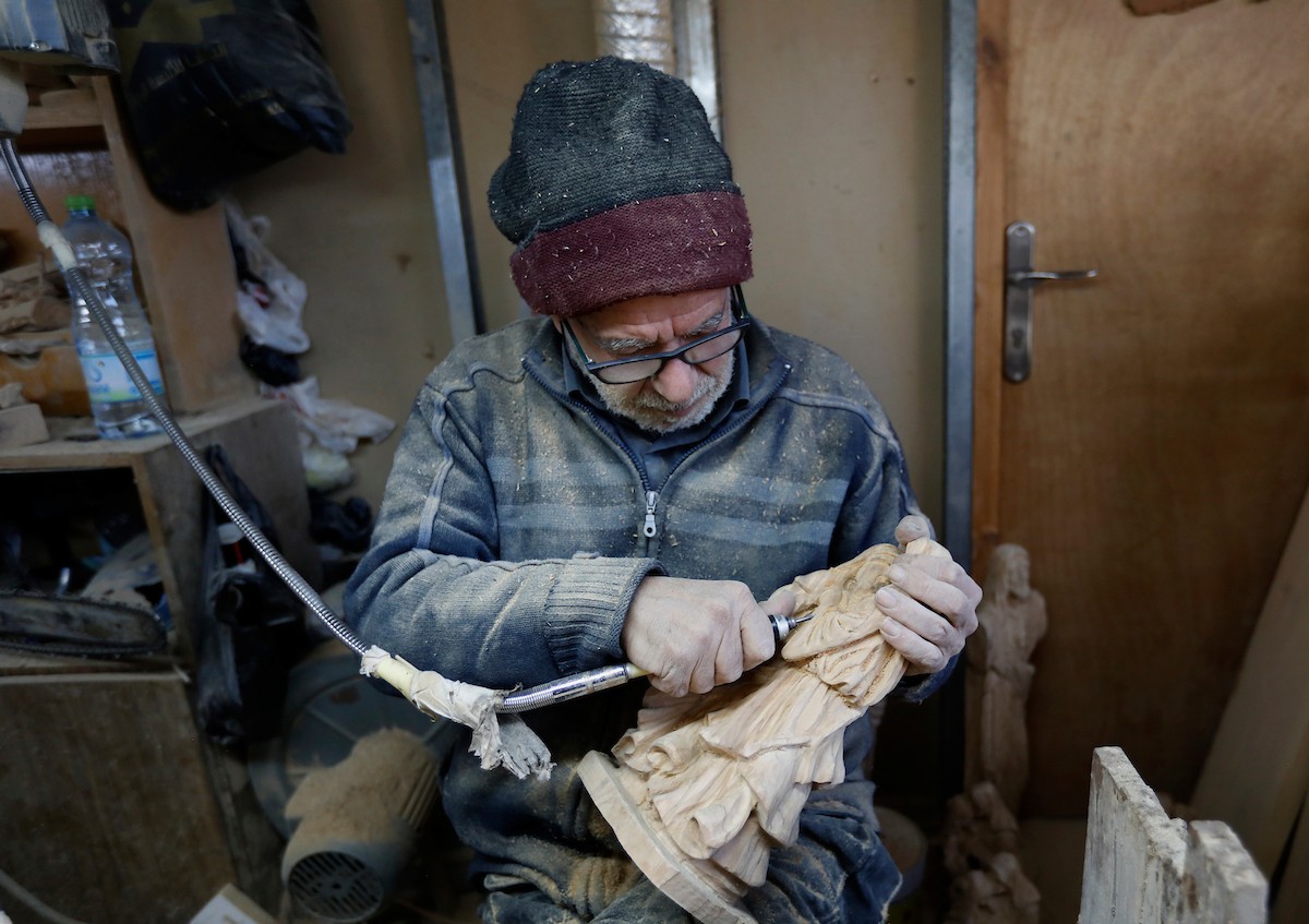 نحت خشب الزيتون في بيت لحم لصنع قطع فنية وهدايا متنوعة، تشمل منحوتات دينية وزخارف تقليدية وتذكارات، استعدادًا لعيد الميلاد، 18 ديسمبر/كانون الأول 2025 تصوير: مأمون وزواز/ (apa)