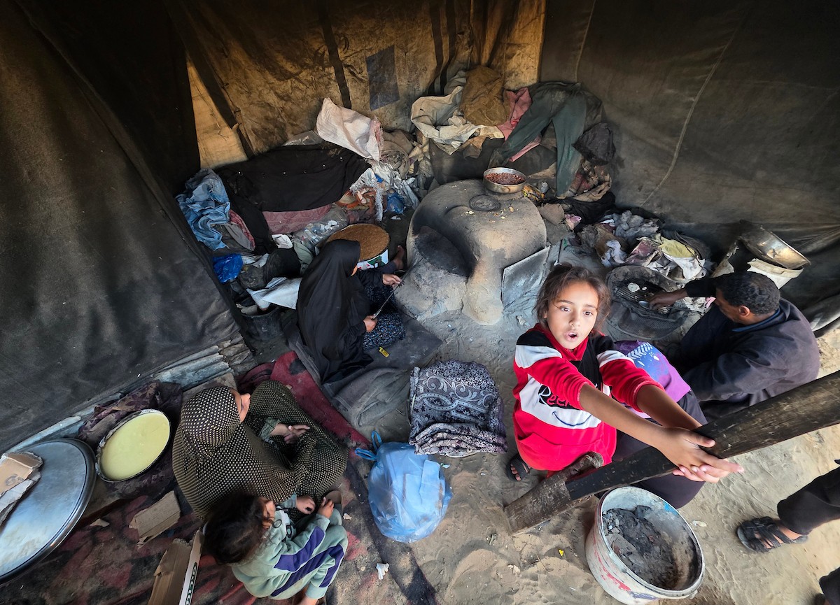 يتجمع فلسطينيون حول أفران طينية مؤقتة لطهي الطعام في قطاع غزة، بعد عشرة أسابيع من وقف إطلاق النار، في ظل شحّ غاز الطهي بسبب القيود الإسرائيلية على دخوله إلى القطاع