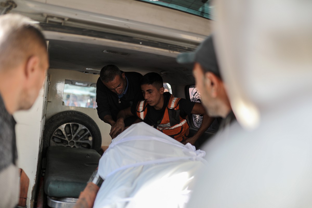 فلسطينيون ينعون ويحملون جثامين عدد من القتلى في غارة إسرائيلية على بيت لاهيا، بينهم أحد عناصر الدفاع المدني، خلال جنازة في مستشفى الشفاء بمدينة غزة