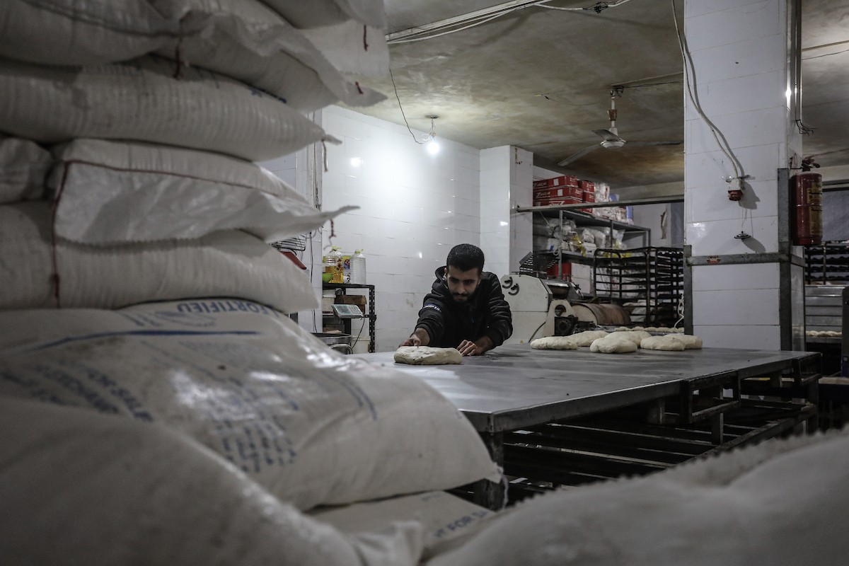 عمال فلسطينيون يعيدون تشغيل أحد أقدم المخابز في مخيم النصيرات للاجئين بعد إغلاقه لمدة عامين بسبب الحرب (27).jpg
