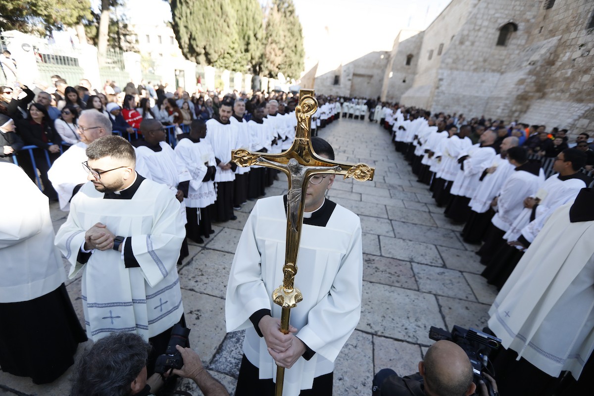البطريرك اللاتيني للقدس، الكاردينال الإيطالي بييرباتيستا بيتسابالا يستقبل الحجاج والسياح لدى وصوله لترؤس قداس منتصف الليل في كنيسة المهد بمدينة بيت لحم، 24 ديسمبر/كانون الأول 2025،  (صور: مأمون وزواز/ apa)