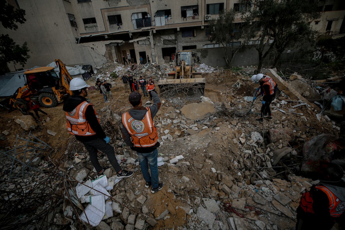 عمال الدفاع المدني الفلسطيني يبحثون عن جثث في مبنى منهار يعود لعائلة سالم، استُهدف بغارات إسرائيلية في بداية الحرب، في شارع الجلاء بمدينة غزة، يوم الاثنين 15 ديسمبر/كانون الأول 2025. صورة: عمر أشتوي