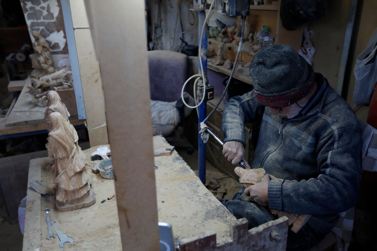 نحت خشب الزيتون في بيت لحم لصنع قطع فنية وهدايا متنوعة، تشمل منحوتات دينية وزخارف تقليدية وتذكارات، استعدادًا لعيد الميلاد، 18 ديسمبر/كانون الأول 2025 تصوير: مأمون وزواز/ (apa)