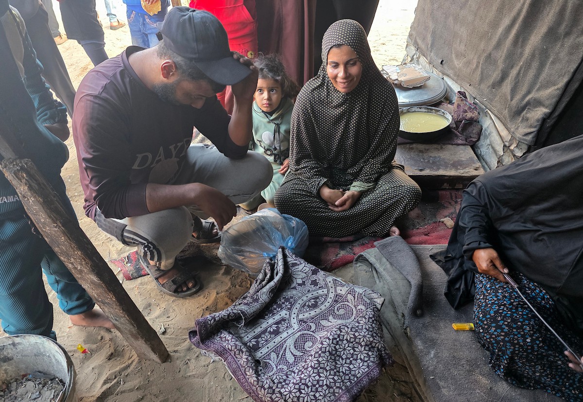 يتجمع فلسطينيون حول أفران طينية مؤقتة لطهي الطعام في قطاع غزة، بعد عشرة أسابيع من وقف إطلاق النار، في ظل شحّ غاز الطهي بسبب القيود الإسرائيلية على دخوله إلى القطاع