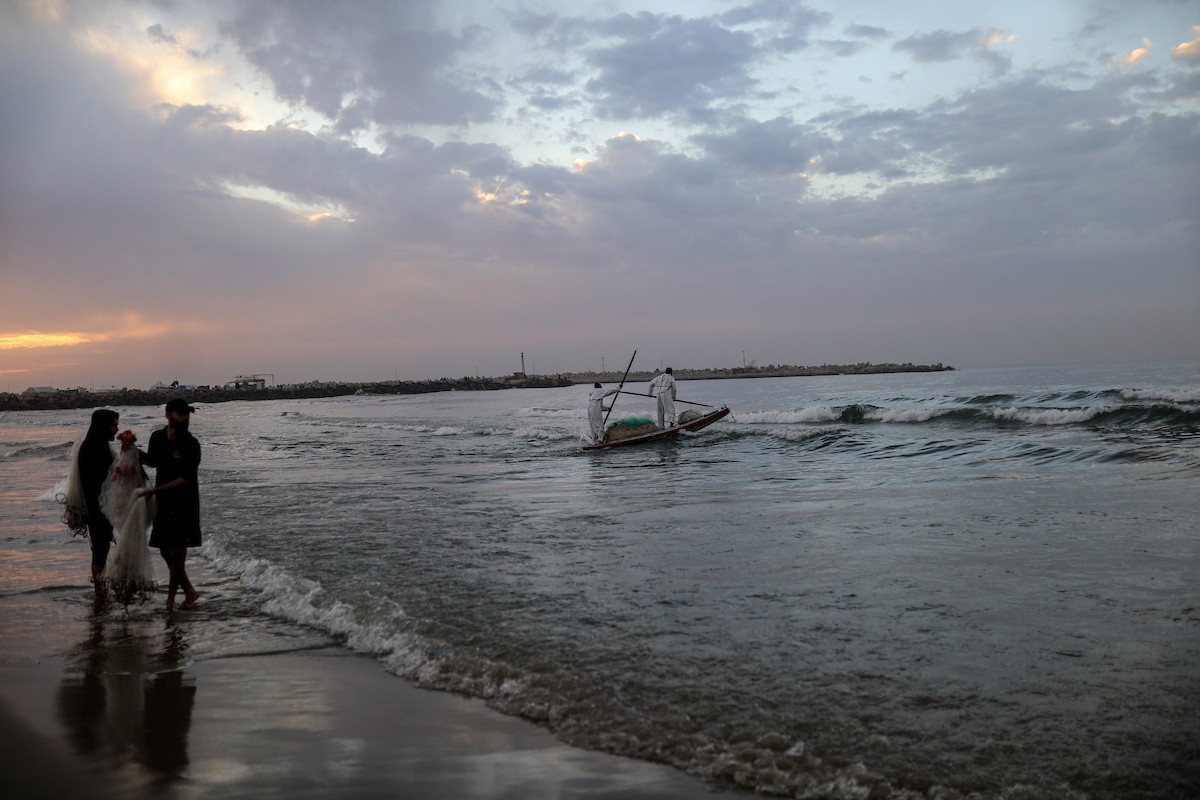 يقضي فلسطينيون نازحون وقتًا على الشاطئ مقابل خيامهم الممتدة على طول ميناء غزة، في غزة، 5 ديسمبر/كانون الأول 2025. تصوير: عمر أشتوي