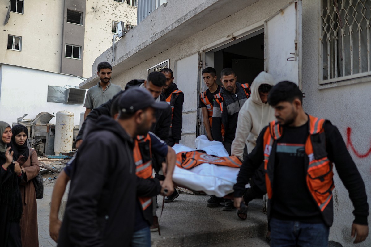 فلسطينيون ينعون ويحملون جثامين عدد من القتلى في غارة إسرائيلية على بيت لاهيا، بينهم أحد عناصر الدفاع المدني، خلال جنازة في مستشفى الشفاء بمدينة غزة