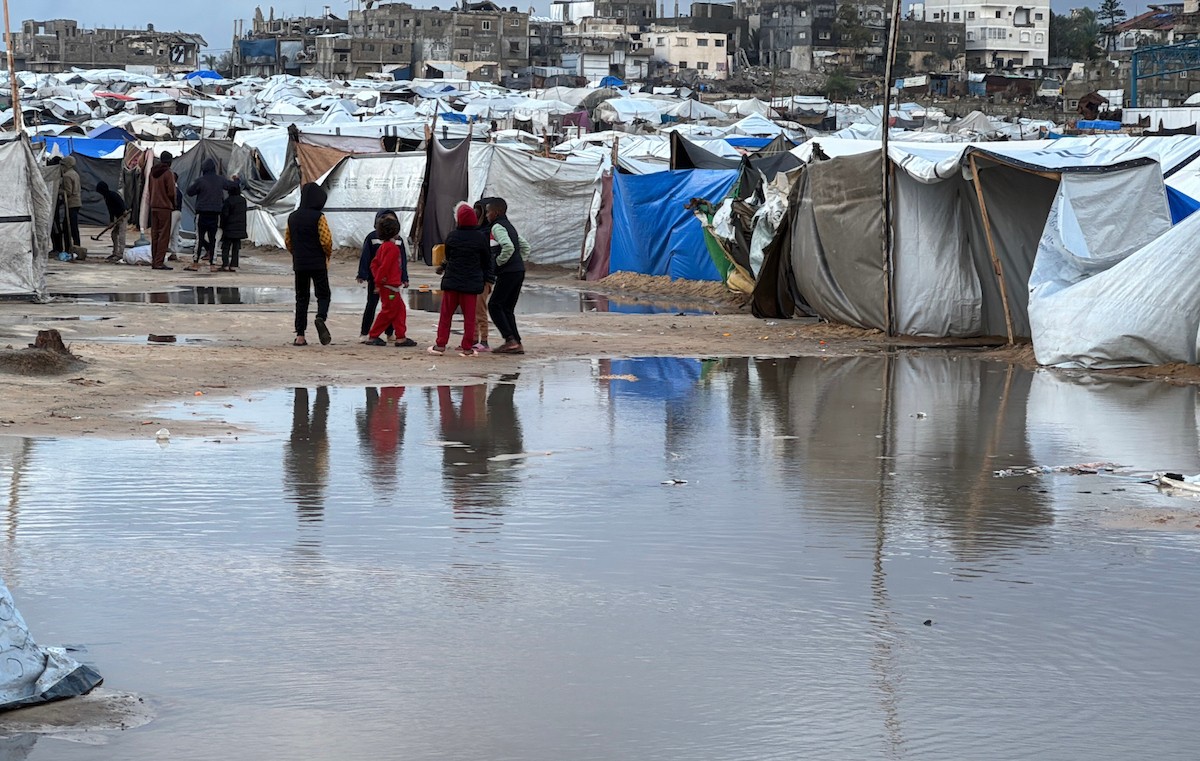 يُكافح الفلسطينيون النازحون، المقيمون في خيام مؤقتة، من أجل البقاء في ظل ظروف قاسية، حيث تجتاح الأمطار والعواصف الشديدة دير البلح، وسط قطاع غزة، في 28 ديسمبركانون الأول 2025. صورة أحمد إبراهيم(APA)