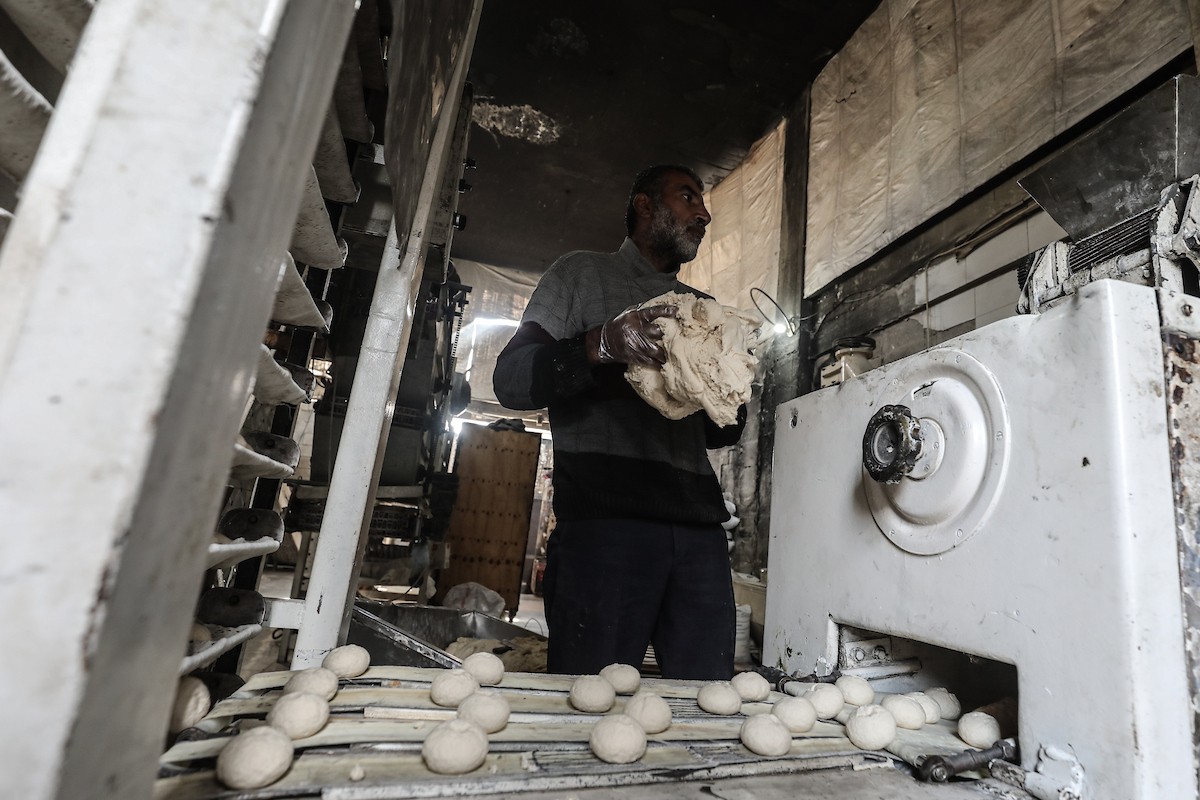 عمال فلسطينيون يعيدون تشغيل أحد أقدم المخابز في مخيم النصيرات للاجئين بعد إغلاقه لمدة عامين بسبب الحرب (16).jpg