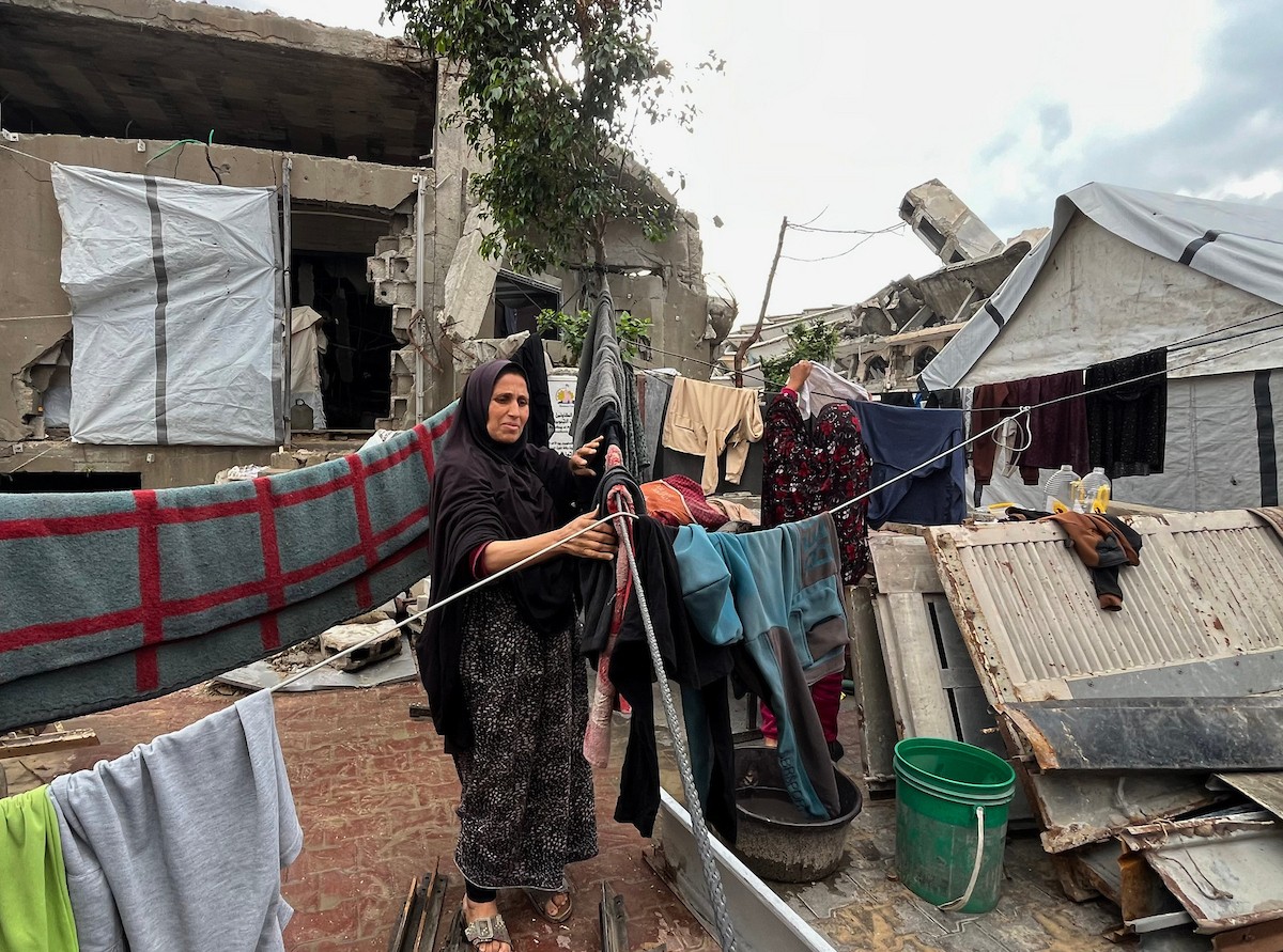 يعيش أشرف وشادية السرساوي مع أحفادهما العشرة داخل خيمة مؤقتة نُصبت في مبنى غير آمن إنشائياً غرب مدينة غزة، وسط تدهور الأوضاع الإنسانية.18 ديسمبر/كانون الأول 2025. صورة: مطر الزاق