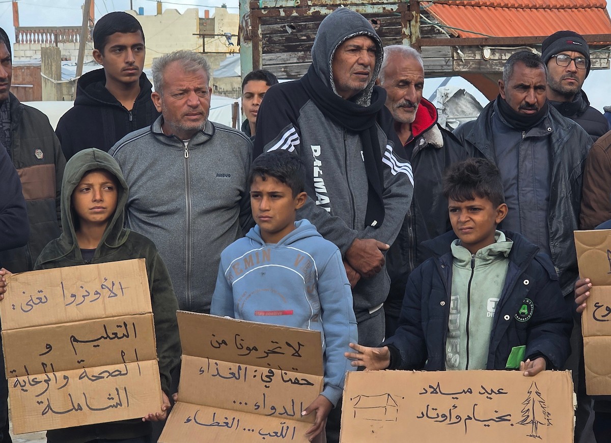 اعتصامٌ نظّمه ائتلاف رفح للنازحين أمام مقرّ الأونروا في منطقة فاش فرش، غرب رفح، للمطالبة بتفعيل الوكالة لدورها الإنساني، ولتسليط الضوء على معاناة النازحين ومطالبهم العادلة. رفح، جنوب قطاع غزة، 28 ديسمبر/كانون الأول 2025. تصوير: طارق محمد (APA ).