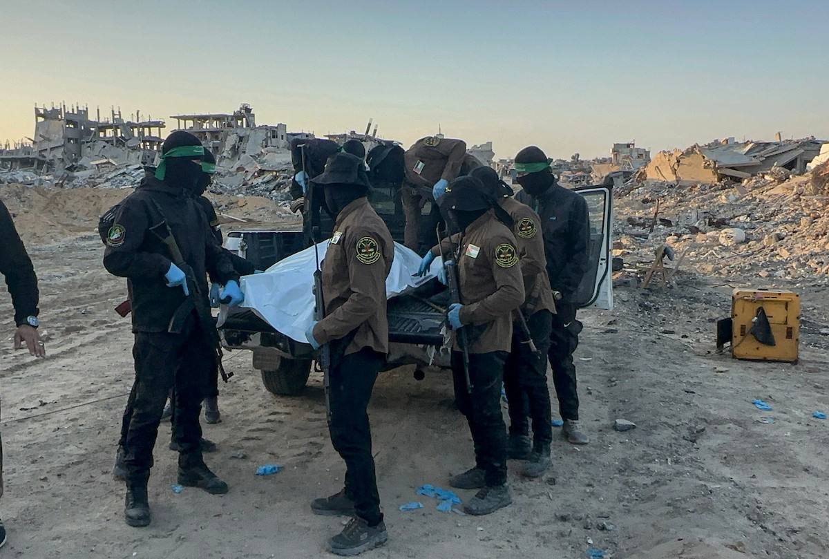 مسلحون من حماس والجهاد الإسلامي في فلسطين يسلمون لأفراد الصليب الأحمر جثة استعادوها من بيت لاهيا قبل تسليمها لإسرائيل لتحديد ما إذا كانت تعود لأحد الرهائن، شمال قطاع غزة، 3 ديسمبر/كانون الأول 2025