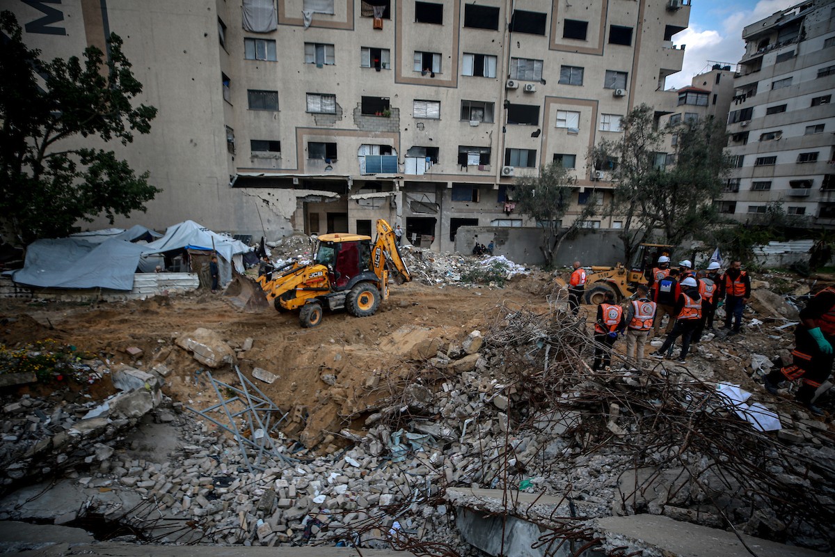 عمال الدفاع المدني الفلسطيني يبحثون عن جثث في مبنى منهار يعود لعائلة سالم، استُهدف بغارات إسرائيلية في بداية الحرب، في شارع الجلاء بمدينة غزة، يوم الاثنين 15 ديسمبر/كانون الأول 2025. صورة: عمر أشتوي