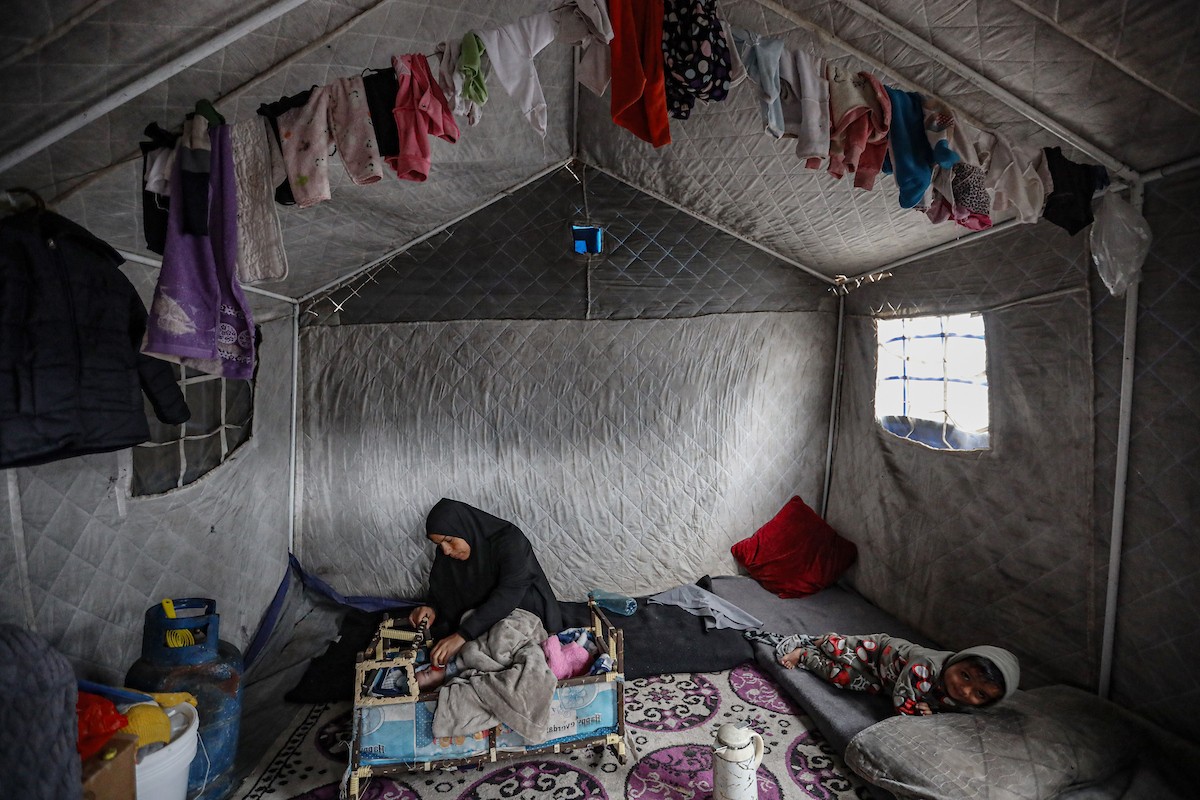 عائلة فلسطينية نازحة مكونة من ستة أفراد  تكافح وسط ظروف غير إنسانية من أجل حماية أطفالها من أجواء الشتاء القارس في  خيمة مهترئة بملعب اليرموك في مدينة غزة، 29 ديسمبر/كانون الأول 2025 صورة: عمر أشتوي