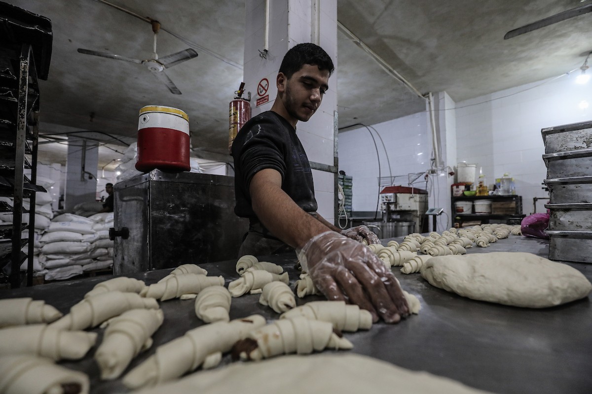عمال فلسطينيون يعيدون تشغيل أحد أقدم المخابز في مخيم النصيرات للاجئين بعد إغلاقه لمدة عامين بسبب الحرب (5).jpg