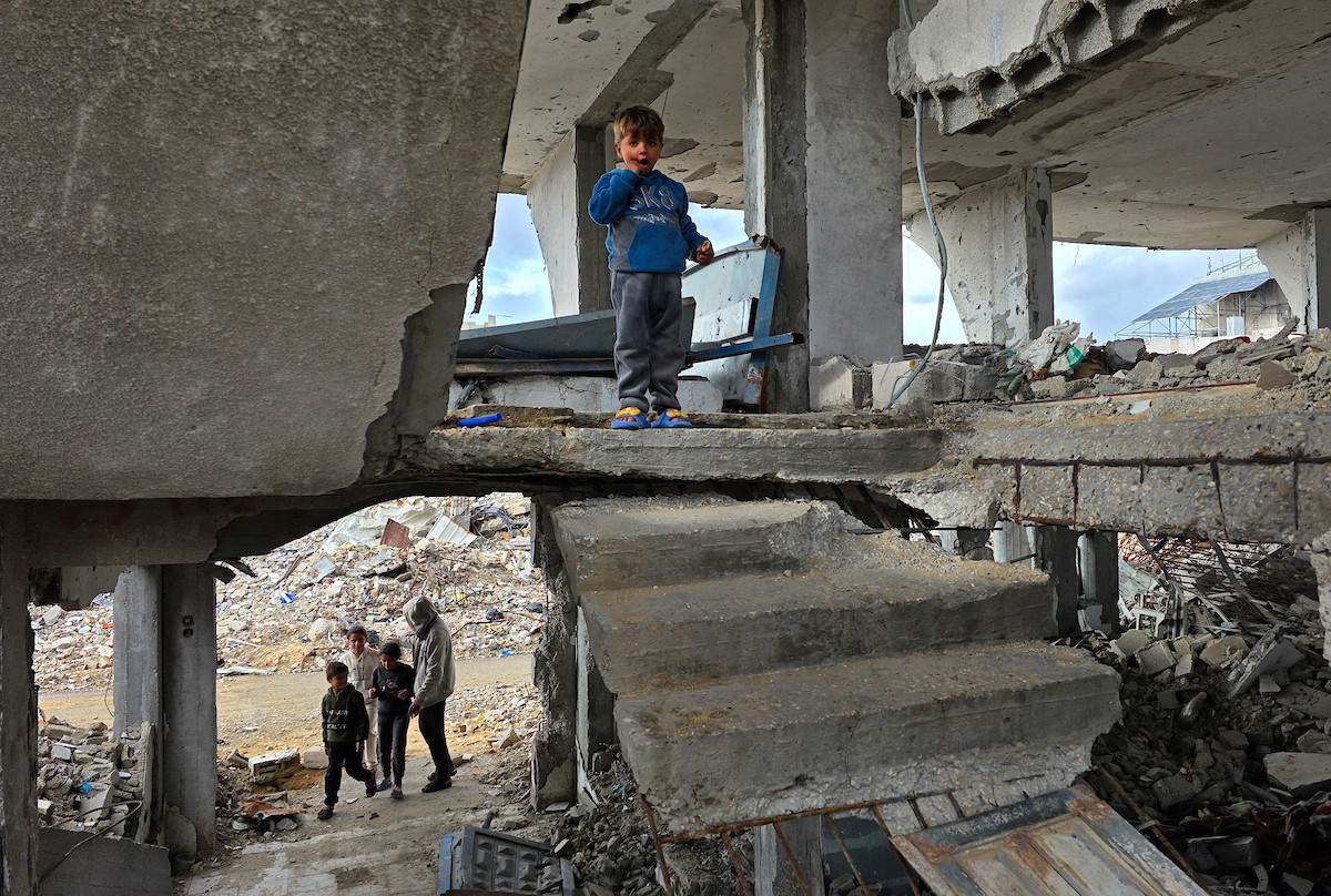 عائلة فلسطينية تحتمي من برد الشتاء القارس في خيمة نصبتها فوق منزلها المدمر قرب الخط الأصفر في خان يونس، جنوب قطاع غزة، ١٧ ديسمبر/كانون الأول ٢٠٢٥. تصوير: طارق محمد/وكالة الأنباء الفلسطينية (APA )